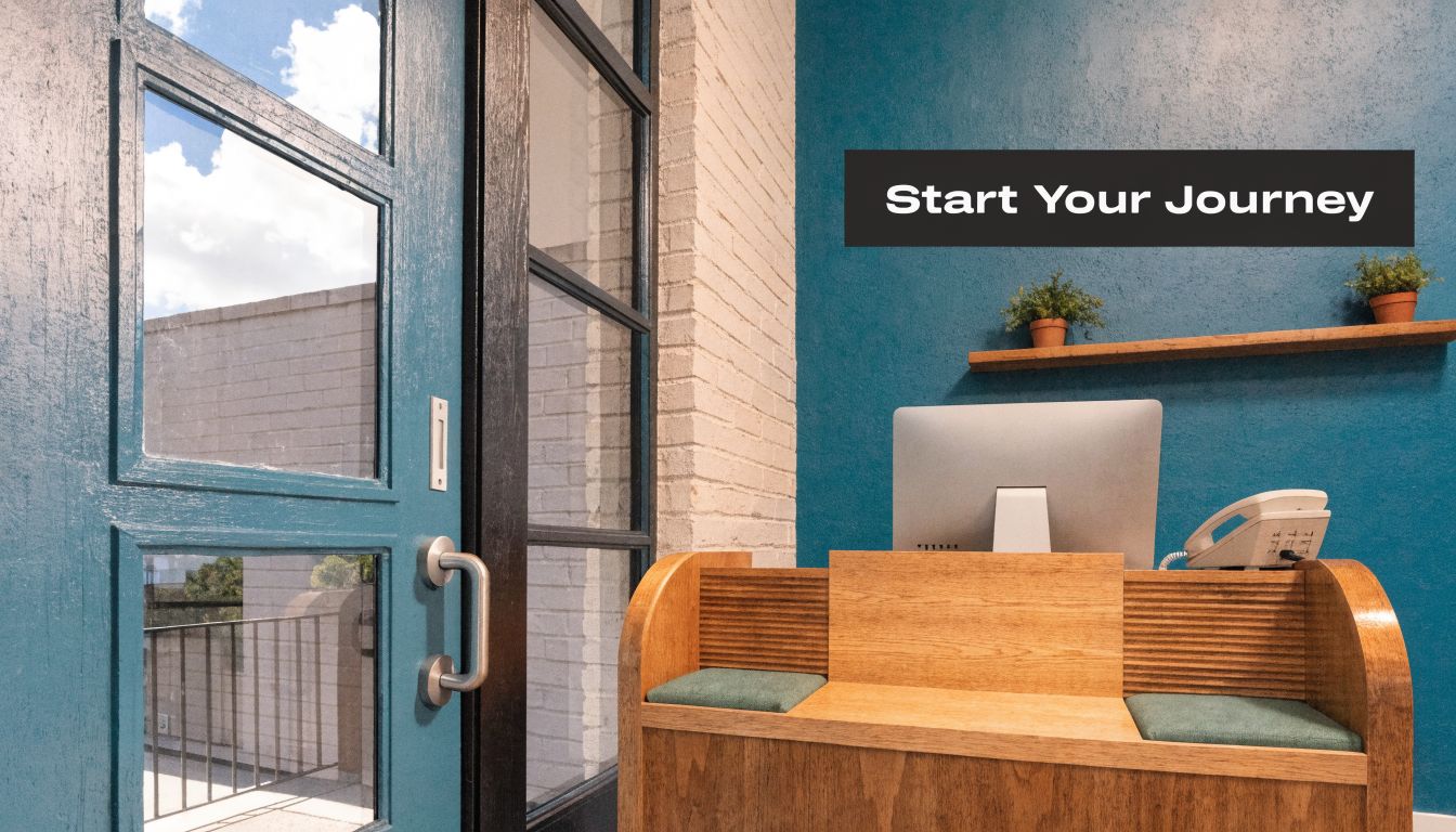 A welcoming professional office reception desk with a computer and plants against a teal blue wall.