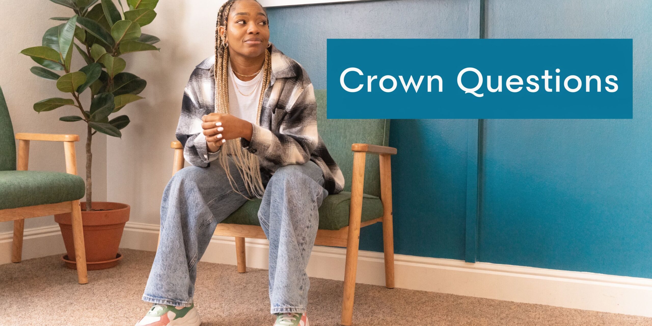 A young woman sits in a waiting room chair looking thoughtfully towards the blue wall text.