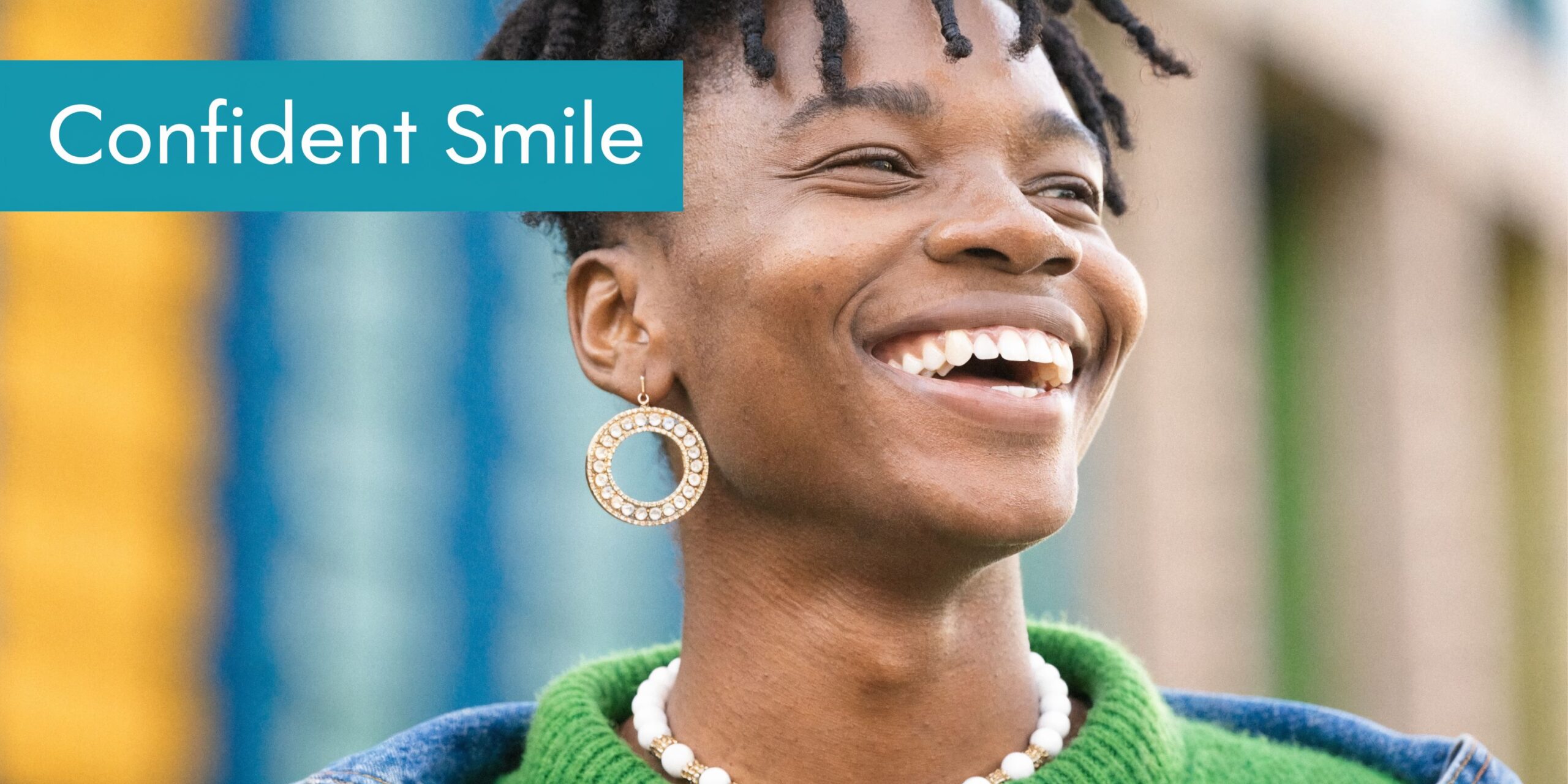 A close up portrait of a young person with a confident smile showing off healthy, white teeth.