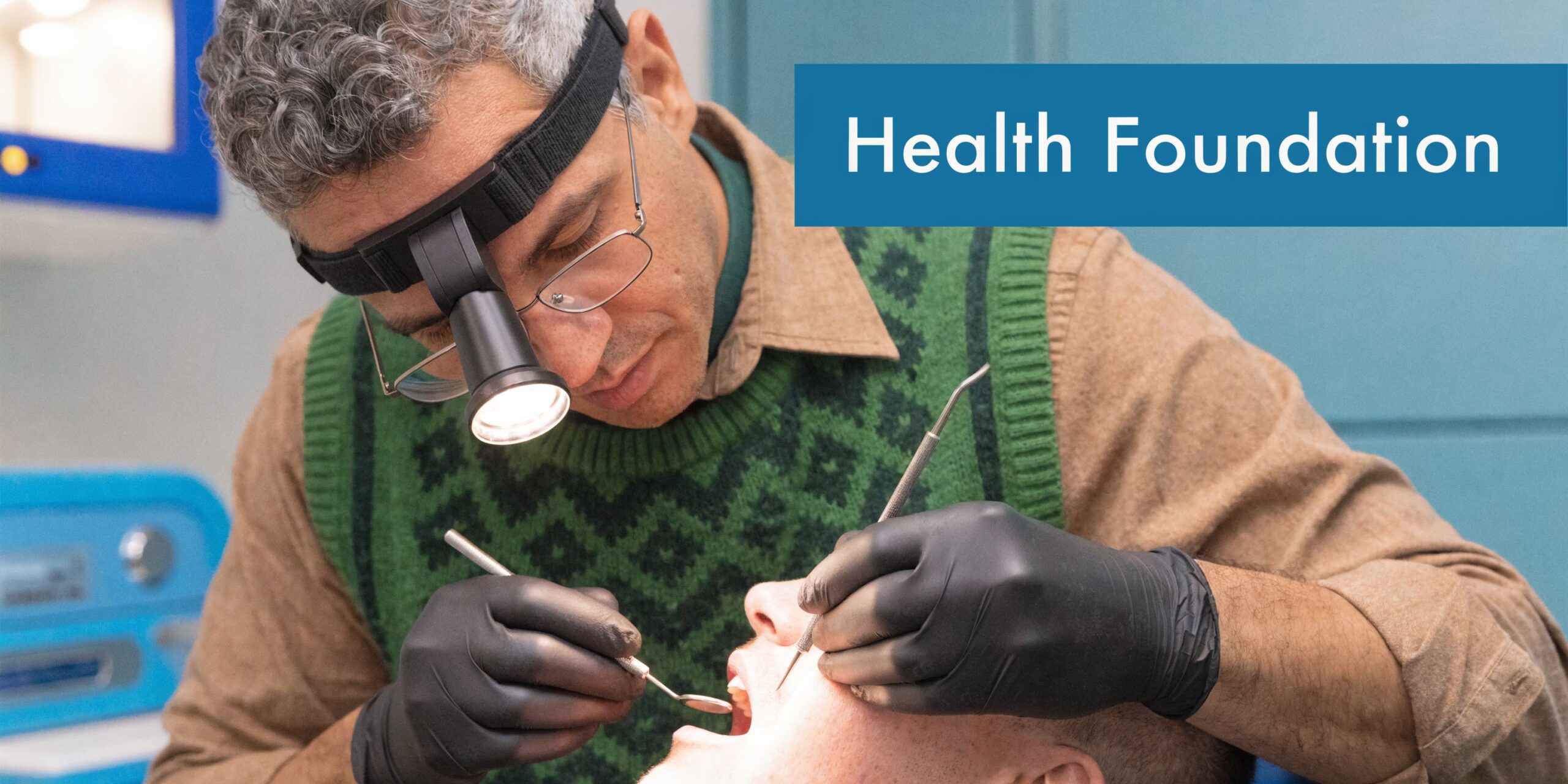 A professional dentist wearing a headlamp and black gloves performing a thorough dental examination on a patient.