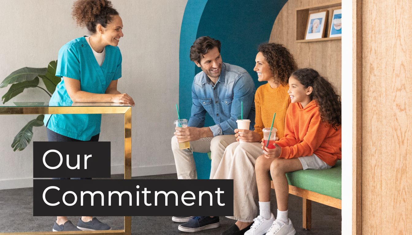 A friendly dental receptionist greets a smiling family at the office front desk in a welcoming setting.