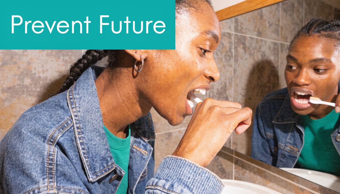 A person brushing their teeth while looking into a bathroom mirror in this studio portrait.